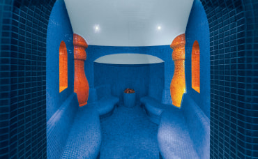 Steam sauna interior with blue tiles and ambient lighting
